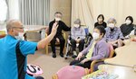 家族に見守られながら発声トレーニングに励む利用者たち＝１５日、米子市彦名町のあわしまデイケアセンター