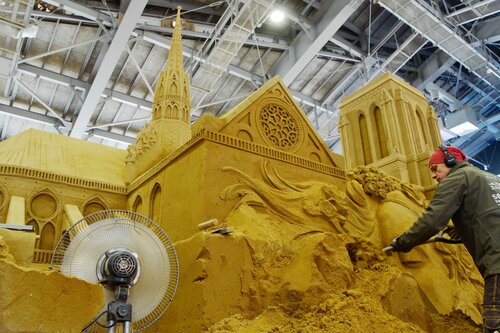 ノートルダム大聖堂を約２０分の１スケールで制作する砂像彫刻家＝２２日、鳥取市福部町湯山の鳥取砂丘砂の美術館