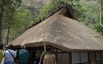 かやぶき屋根の魅力に触れる観光客ら＝１８日、智頭町芦津の「みたき園」