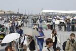 　大阪メトロ夢洲駅（右奥）を利用して万博会場に向かう人たち＝４月、大阪市此花区の夢洲