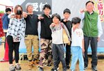 １万人目となった岡田さん一家と山桝会長（右）