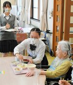 入所者の食事を介助する生徒たち＝２９日、米子市彦名町