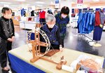 会場で綿から糸を紡ぐ作業を実演する保存会員