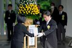 　千鳥ケ淵戦没者墓苑で開かれた拝礼式で、新たに納骨する遺骨を受け取る福岡厚労相＝２６日午後、東京都千代田区