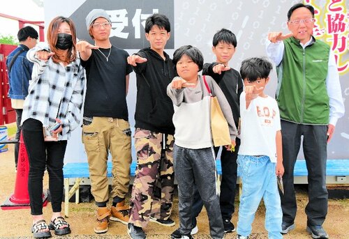 １万人目となった岡田さん一家と山桝会長（右）