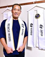 優勝者に贈られる金色に縁取られたサッシュを手にする井藤さん
