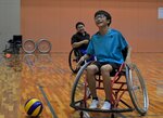 上原さん（中央奥）の指導で、車椅子でのボール拾いに挑戦する参加者