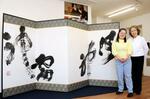 　作品「風神雷神」の横に立つ金沢翔子さん（左）と泰子さん＝東京都大田区