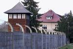　アウシュビッツ強制収容所跡に立つ監視塔。奥は元所長ヘスの一家が暮らした邸宅＝２６日、ポーランド南部オシフィエンチム（共同）
