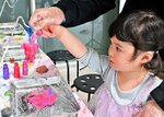 キーホルダー作りのワークショップを楽しむ子ども＝１７日、鳥取市湖山町西４丁目の鳥取砂丘コナン空港