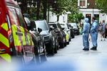 　火災のあったスターマー英首相の私邸付近で捜査に当たる警察官ら＝１２日、ロンドン（ゲッティ＝共同）