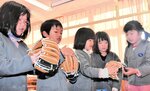 大谷選手から贈られたグラブをはめて感触を確かめる児童たち＝９日、香美町村岡区村岡の村岡小