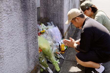 　岡崎彩咲陽さんが見つかった住宅前で手を合わせる親族（手前）ら＝４日午後、川崎市川崎区