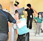 防火衣で作られた防災頭巾をかぶり、避難訓練を行う児童ら＝９日、鳥取市伏野の白兎養護学校