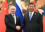 　会談で握手するロシアのプーチン大統領（左）と中国の習近平国家主席＝２０２３年１０月、北京の人民大会堂（タス＝共同）